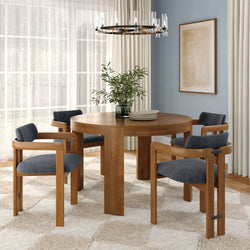 Modern dining room with round oak table, wood chairs with dark velvet seats, glass chandelier, sheer curtains, potted plant