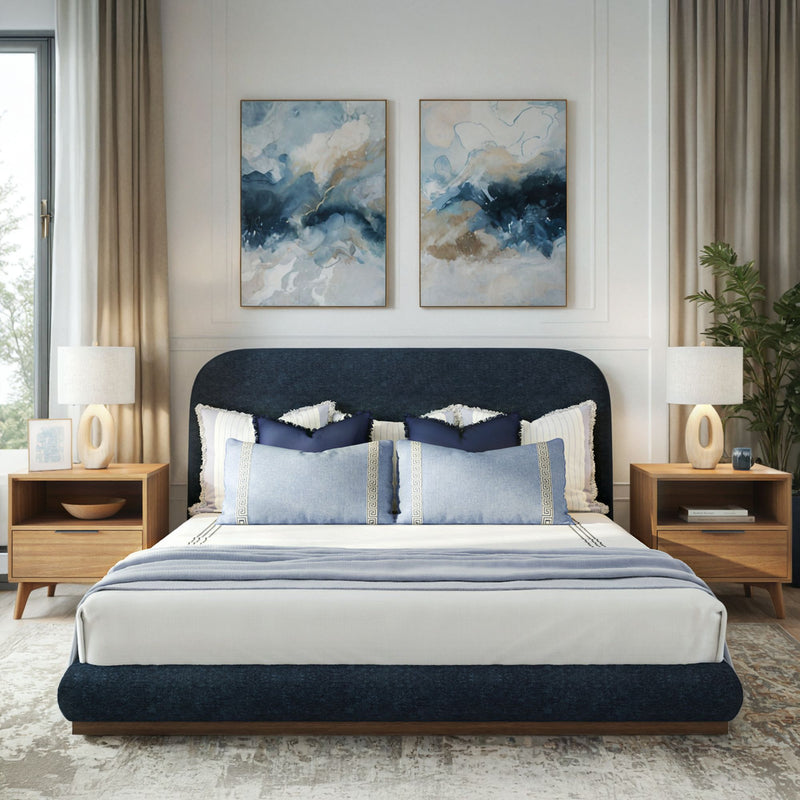 Modern bedroom interior with elegant blue bed, abstract paintings, and wooden furniture.