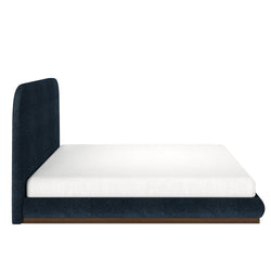Modern platform bed with blue upholstered frame and white mattress.
