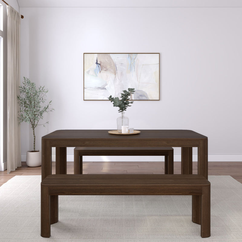 Dark wood dining table with matching benches in a minimalist living room featuring a potted plant and abstract wall art.