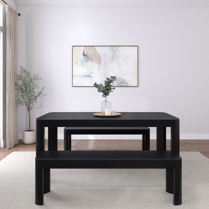 Minimalist dining room with black table and benches, featuring abstract wall art and greenery.