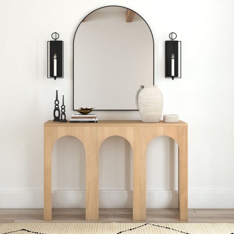 Modern minimalist entryway with wooden console table, large mirror, decorative vases, and wall sconces.