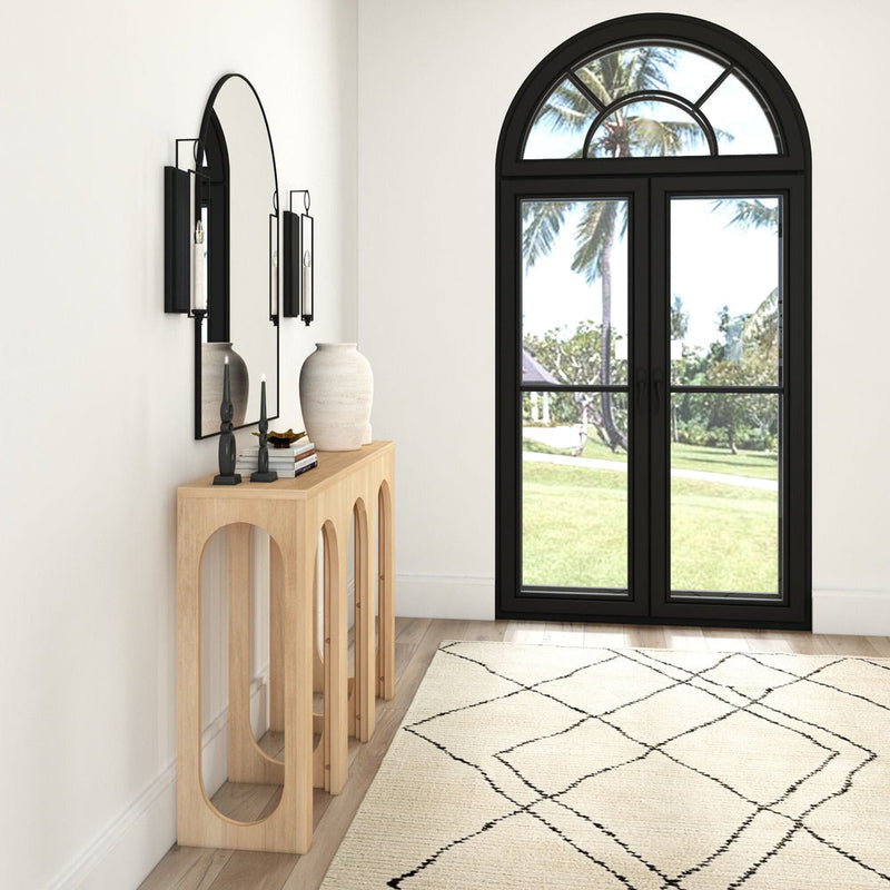 Modern entryway with wooden console table, decorative vases, large mirror, and arched glass door offering outdoor view.