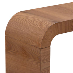 Close-up of curved walnut wood console table corner showing smooth rounded edge and rich wood grain texture