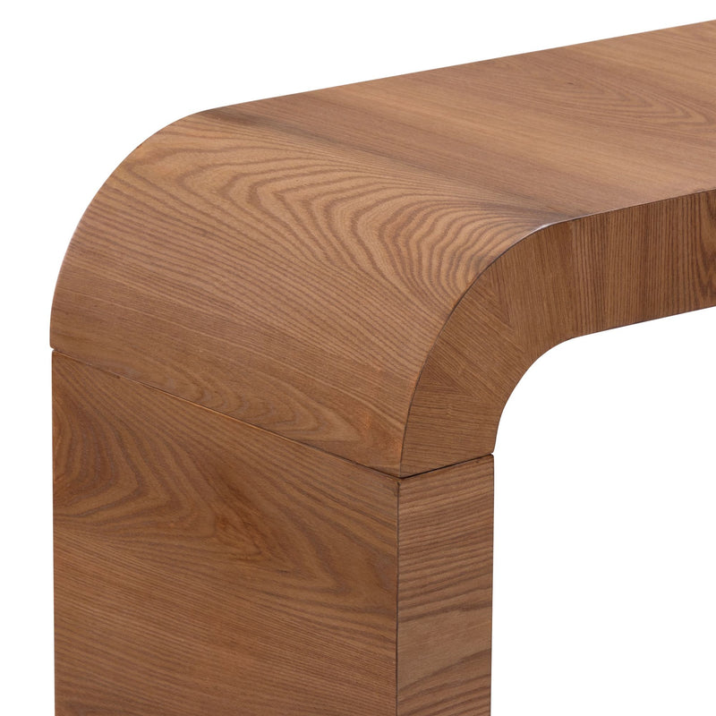 Close-up of curved walnut wood console table corner showing smooth rounded edge and rich wood grain texture