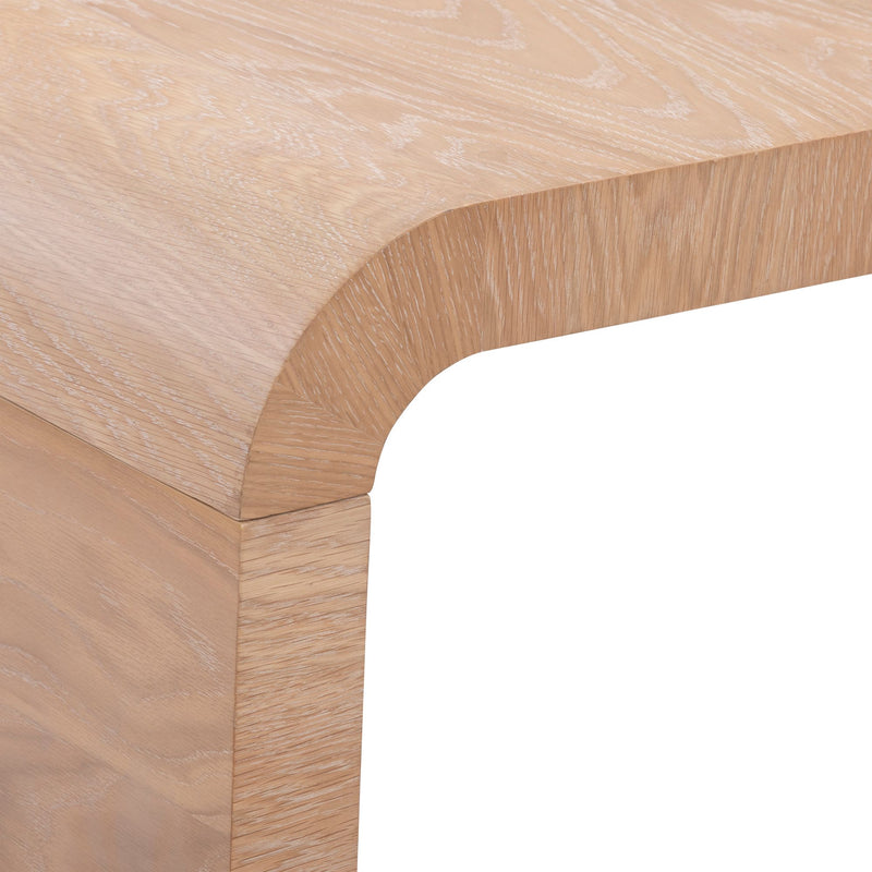 Close-up of light oak wood table corner with rounded edge and visible wood grain finish