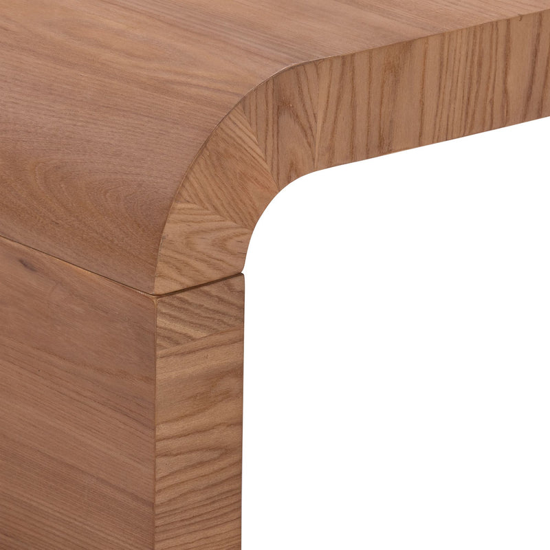 Close-up of a modern wooden table corner with rounded edge and natural wood grain finish