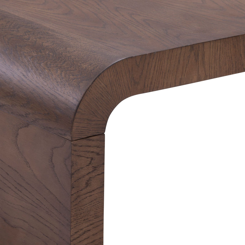 Dark brown wood dining table corner close-up with rounded edge and visible wood grain, modern stained-finish table detail