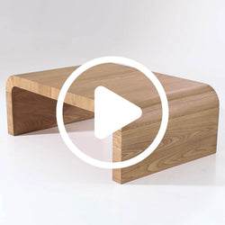 Minimalist curved natural wood coffee table with rounded edges and low-profile modern design on white background