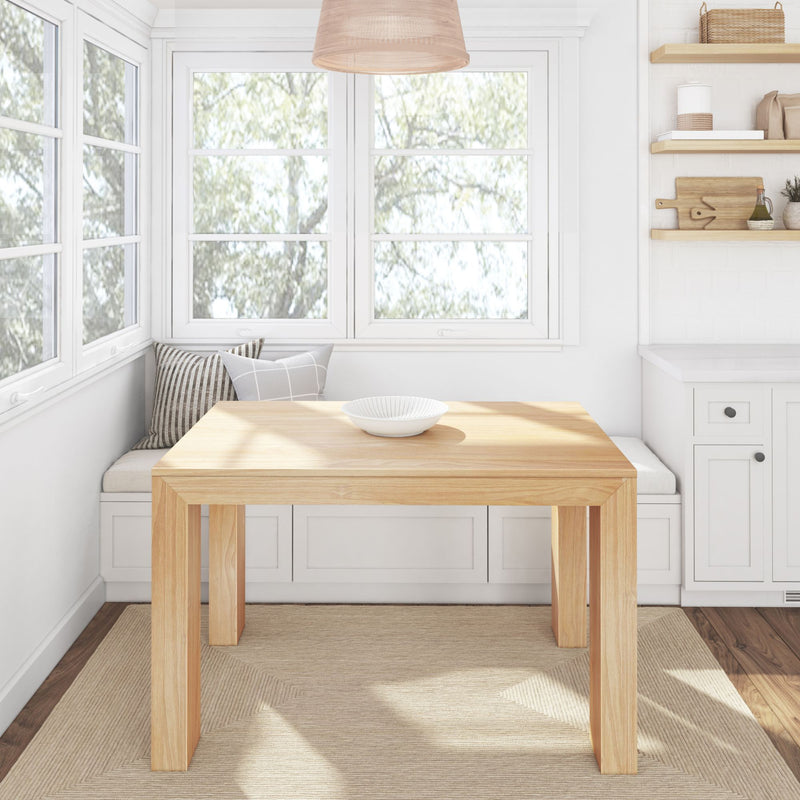 Bright minimalist dining area with a wooden table, white walls, and large windows.