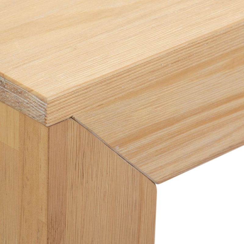 Close-up view of light wood grain texture and corner detail on a contemporary wooden furniture piece.