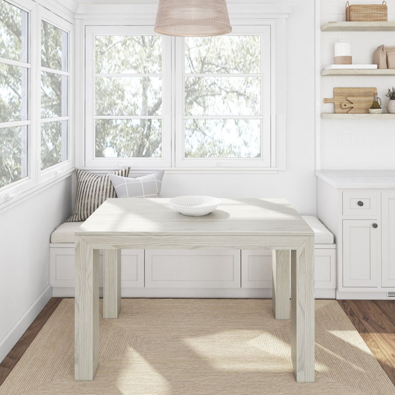 Cozy modern kitchen nook with wooden table, bench seating, and natural light through large windows.