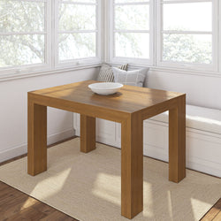Modern wooden dining table with decorative bowl in bright corner nook.