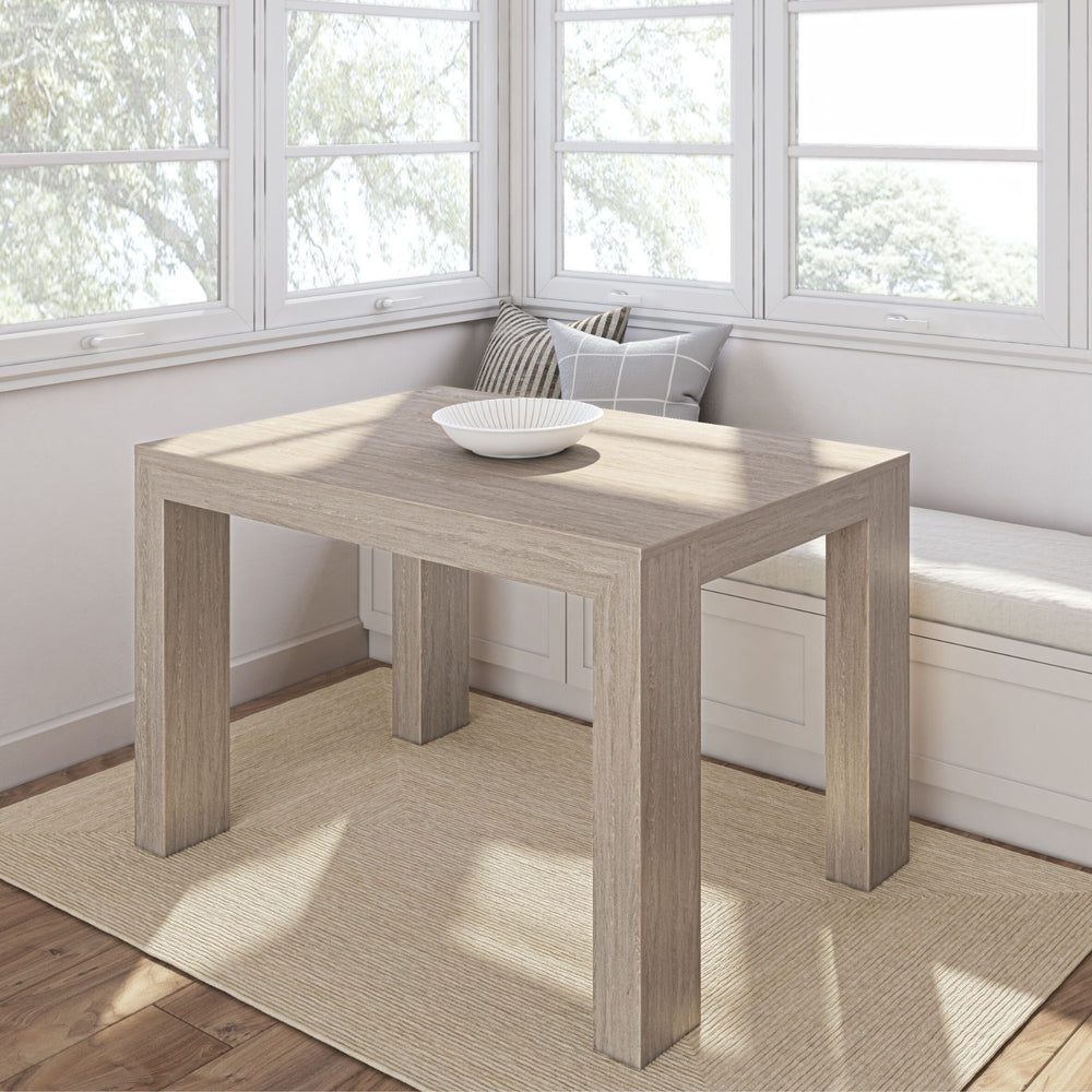 Modern wooden dining table in a bright kitchen nook with white bench seating and natural light.