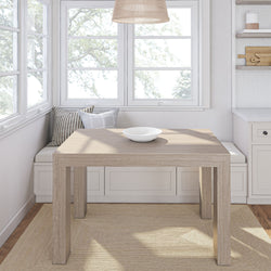 Cozy dining nook with wooden table and cushioned bench seating near large windows.