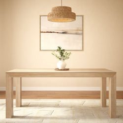 Minimalist dining room with wooden table, modern pendant light, abstract art, and plant vase centerpiece.