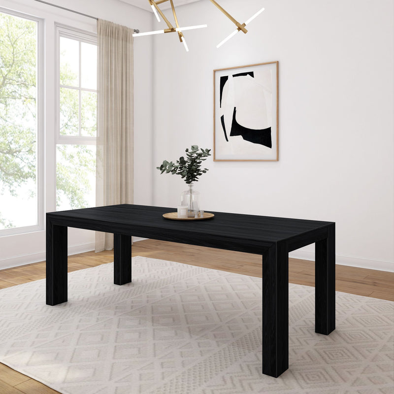 Minimalist modern dining room with black wood dining table, abstract framed wall art, eucalyptus vase centerpiece, brass linear pendant light and soft natural window light