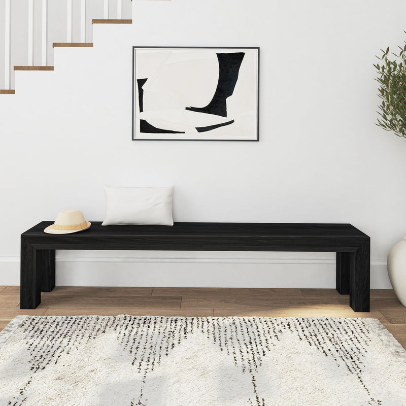 Modern minimalist interior with black bench, abstract wall art, and woven rug.