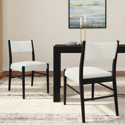 Modern dining room with black table, white chairs, and abstract wall art.