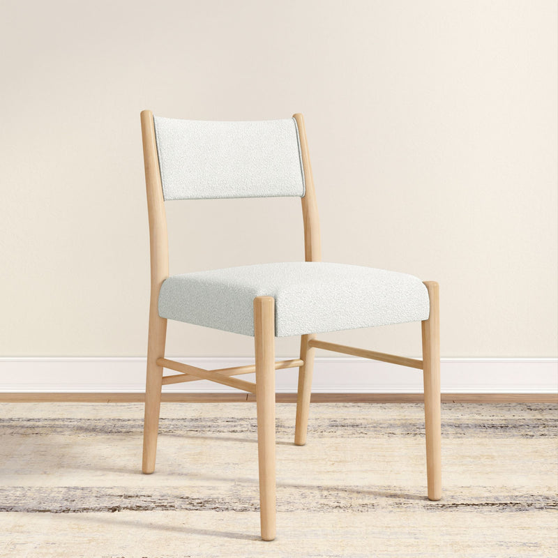 Modern Scandinavian dining chair with white bouclé upholstery and light oak frame on a neutral rug against a beige wall