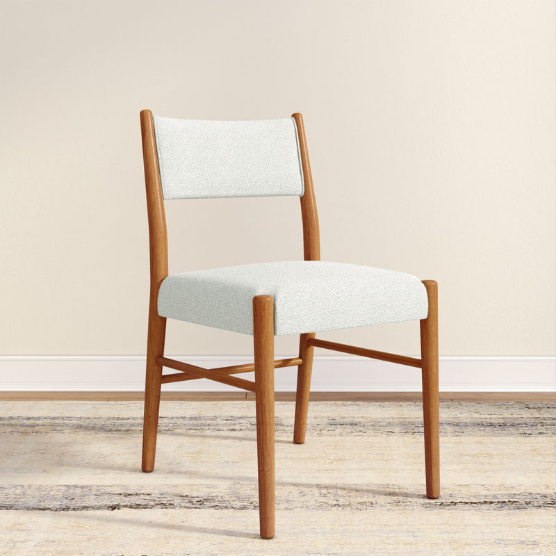 Mid-century modern wooden dining chair with white boucle upholstered seat and back against a beige wall on a light rug