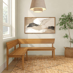 Minimalist wooden L-shaped corner bench in a bright neutral entryway with abstract framed art, woven area rug, pendant light, and potted plant