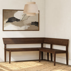 L-shaped dark wood corner dining bench in modern minimalist nook with beige pendant lamp, abstract wall art and woven jute rug