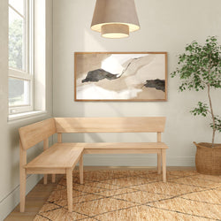 Modern Scandinavian entryway with light wood L-shaped corner bench, neutral abstract wall art, woven jute rug, pendant light and potted indoor plant
