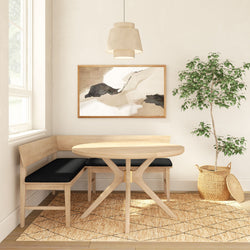 Scandinavian dining nook with round oak table, L-shaped bench with black cushions, neutral abstract wall art, pendant light, potted ficus on jute rug