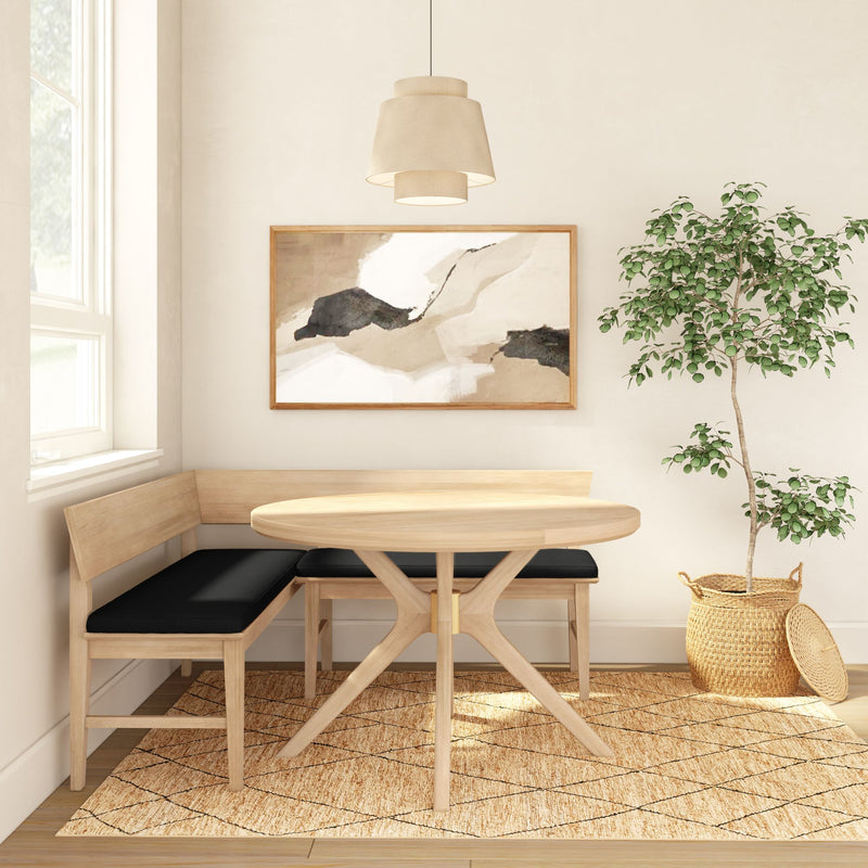 Scandinavian dining nook with round oak table, L-shaped bench with black cushions, neutral abstract wall art, pendant light, potted ficus on jute rug