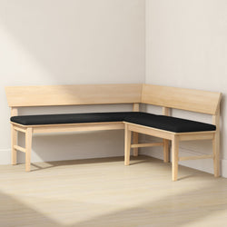 Light wood L-shaped corner bench with black cushions in a minimalist Scandinavian dining nook