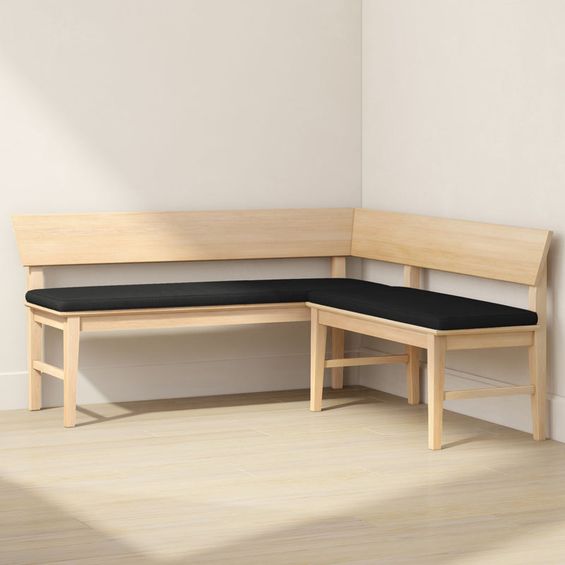 Light wood L-shaped corner bench with black cushions in a minimalist Scandinavian dining nook