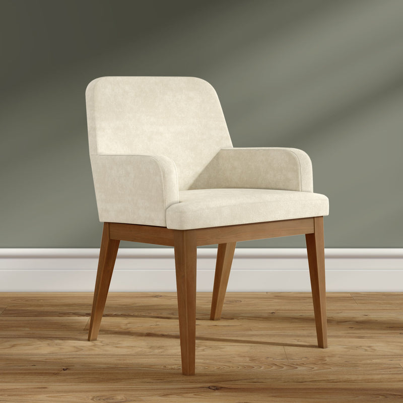 Cream upholstered mid-century modern dining chair with tapered oak legs on hardwood floor against a sage green wall