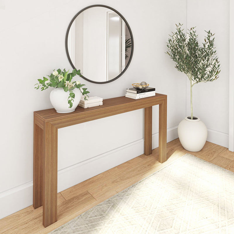 Modern minimalist hallway with wooden console table, round mirror, and decorative plants.