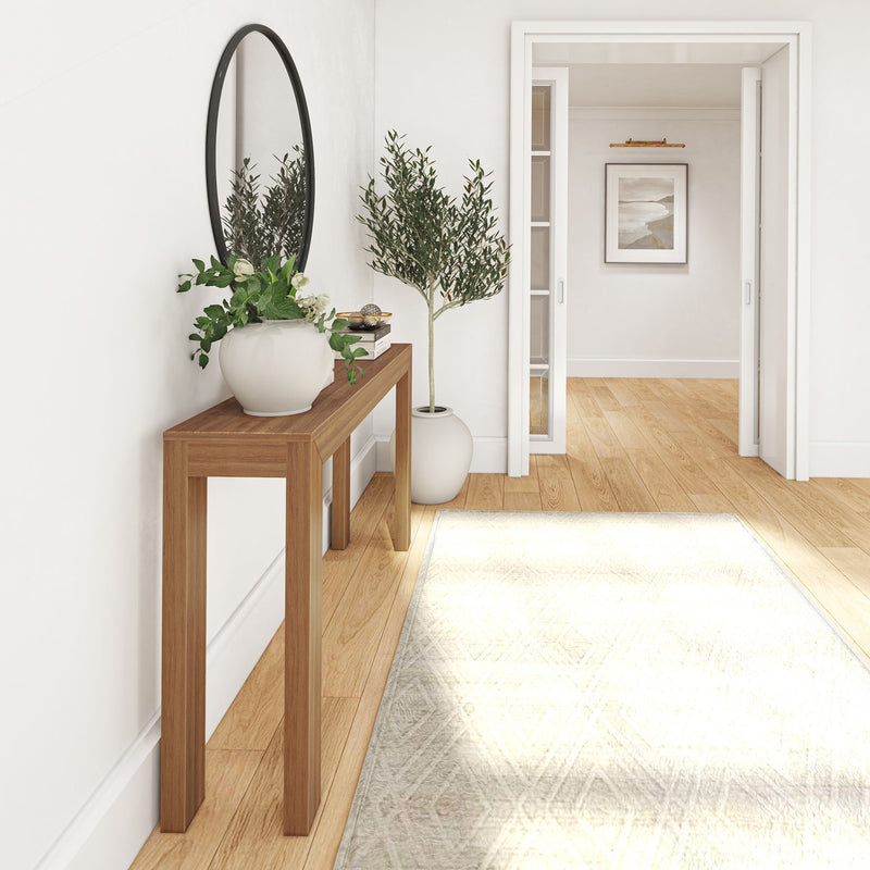 Stylish entryway with wooden console table, decorative plants, and modern round mirror.