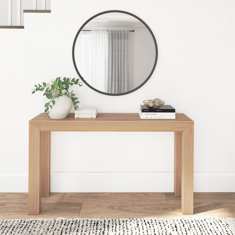 Modern wooden console table with decorative vase and books, round mirror above, minimalist home decor.