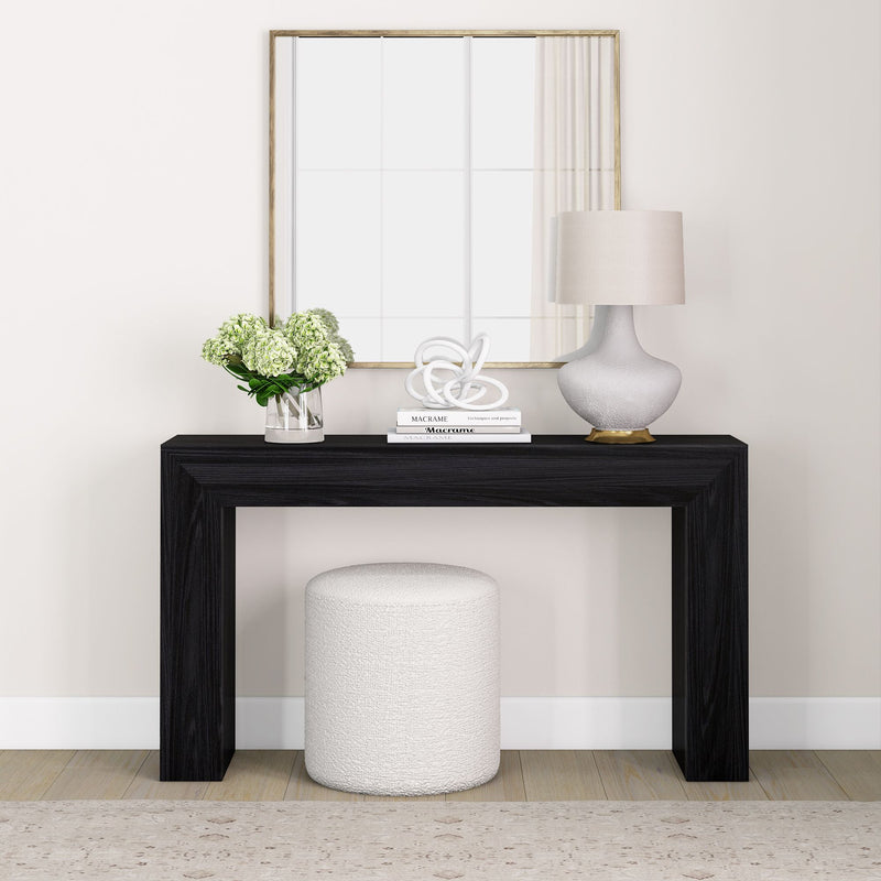 Modern minimalist entryway with black console table, white stool, and decorative accents for home decor inspiration.