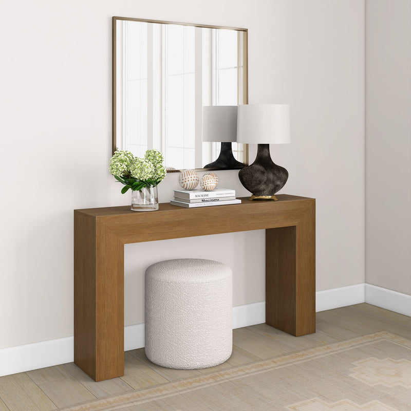 Stylish wooden console table with mirror, decorative lamps, books, and a vase with flowers in a modern living room setting.
