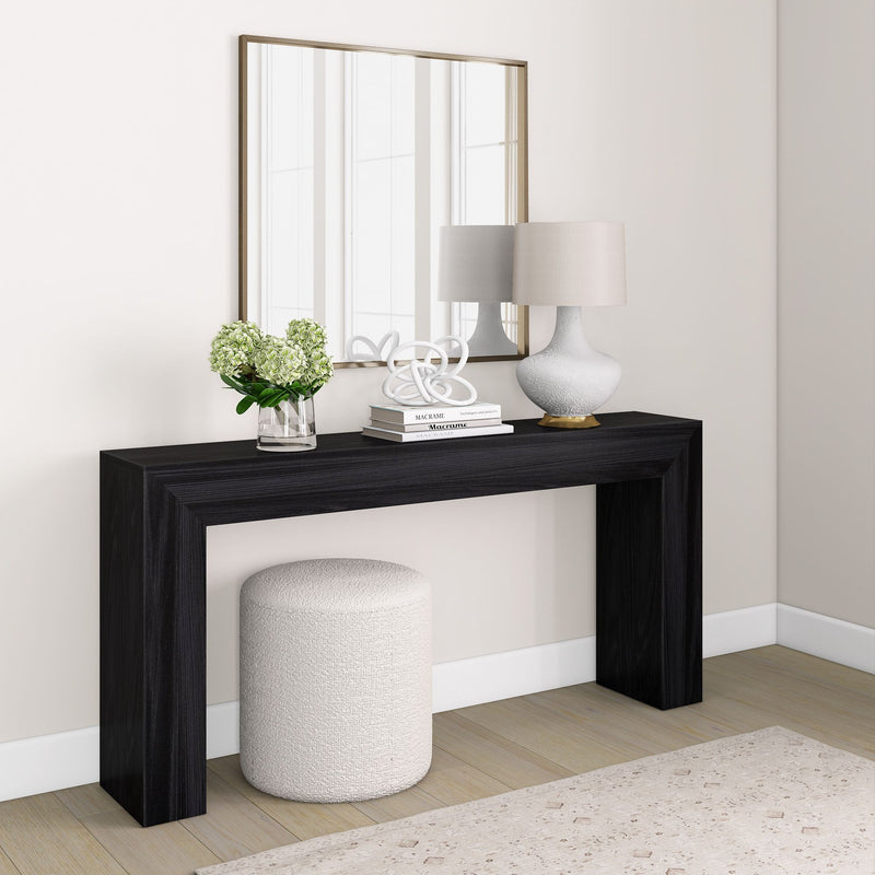 Modern console table with decorative items, large mirror, and ottoman in stylish living room setup.