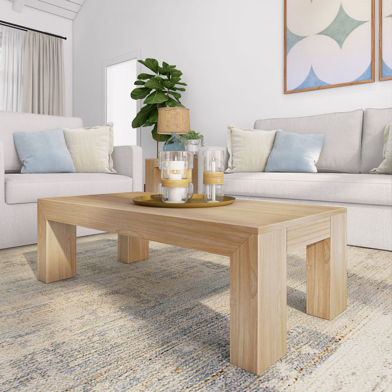 Modern living room with a wooden coffee table, cozy sofas, decorative candles, and a potted plant.