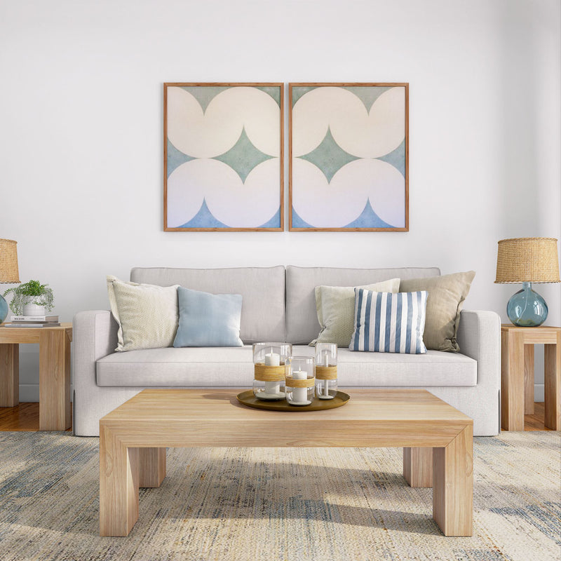 Modern living room with neutral-toned sofa, decorative pillows, abstract wall art, wooden coffee table, and side tables with lamps.