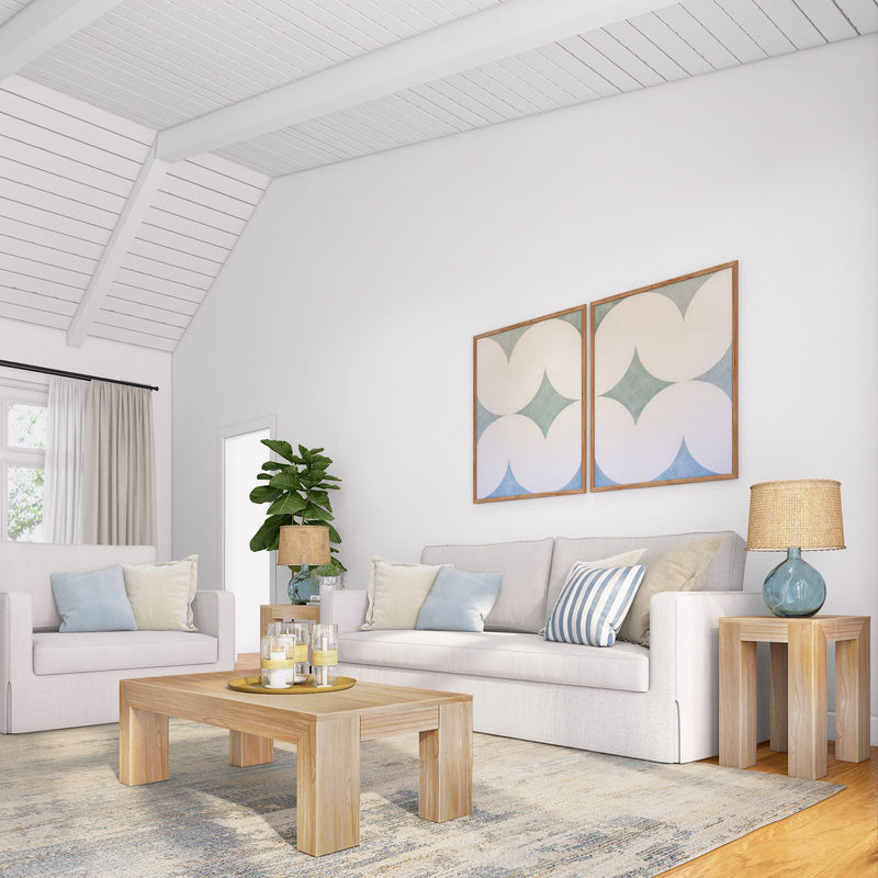 Modern living room with white sofas, wooden coffee table, abstract wall art, and decorative plants.