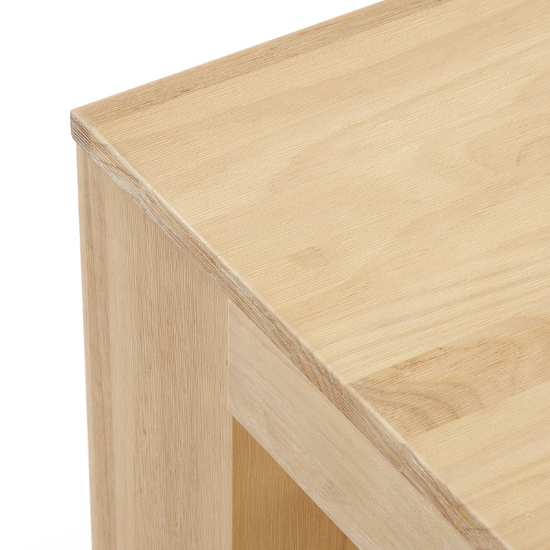 Close-up of a smooth light wood table corner showing natural oak grain texture.