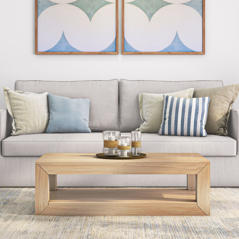 Modern living room with gray sofa, assorted pillows, wooden coffee table, and abstract wall art.