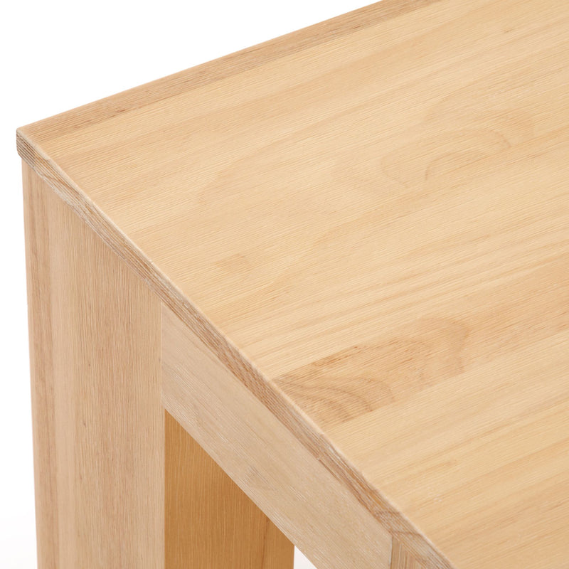 Close-up of a wooden table with a light natural finish, showcasing the grain and smooth surface.