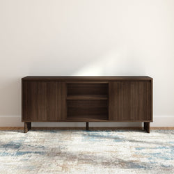 Mid-century modern dark walnut media console sideboard with open shelving and sliding cabinet doors on a patterned area rug in a minimalist living room