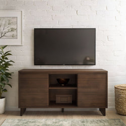 Dark wood TV console beneath wall-mounted flat-screen TV on white brick wall with potted plant and woven basket, minimalist mid-century living room decor