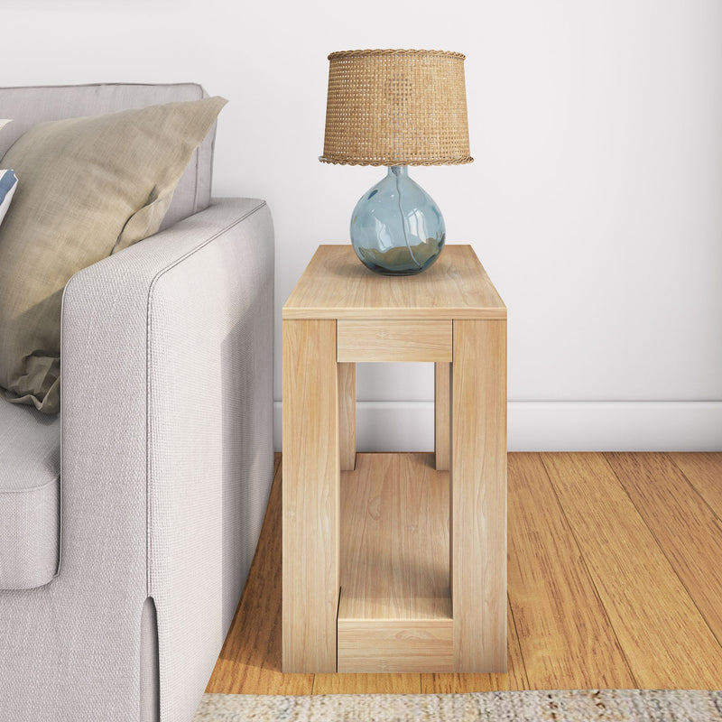 Modern wooden side table with a woven lamp and blue glass base next to a beige sofa in a contemporary living room.