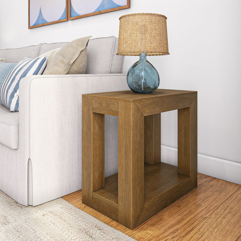Modern living room with a stylish wooden side table, featuring a glass lamp and comfortable sofa.
