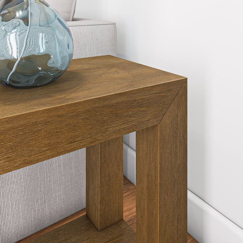 Modern wooden side table near a beige sofa with a decorative glass vase on top.